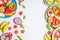 Summer clean and healthy lifestyle background with various colorful sliced tropical fruits and berries plates