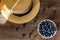 Summer close-up of blueberries and straw hat on vintage wooden background.