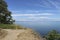 Summer coastal landscape - clear Black Sea under blue sky. Sandy high bank with trees. Copy space