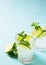 Summer coctail or mocktail mojito with lime and mint leaf on blue background