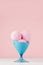 Summer cold dessert - three pink strawberry ice cream balls in elegant blue bowl on white wood table and pastel pink wall.