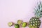 Summer composition. Tropical fruits - pineapple, lime on pastel pink background. Summer concept. Flat lay, top view, copy space