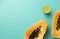 Summer composition. Tropical lime and papaya fruit cut in half lie on a blue background. Summer concept. Flat lay, top view