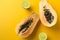 Summer composition. Tropical lime and papaya fruits cut in half lie on a yellow background. Summer concept. Flat lay, copy space