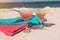 Summer concept: fresh exotic cocktail on sand beach. Colorful towels lying beside. It is at sea shore. Paradise.