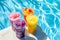 Summer concept - selection of colorful slushie drinks by the pool, vacation vibe