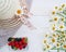 Summer concept, summer berries straw hat and white daisies