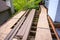 Summer construction, outdoor deck under construction, old support joists with plywood walkway and manufactured planks