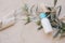 Summer cosmetic still life scene. Oil, shampoo or cream bottle with blue cap. Olive tree branch, fruit and silk ribbon