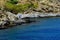 Summer: a cove cliff of cape of the Crosses in Spain with blue sea