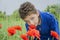 In the summer on the curly boy sniffing poppies.