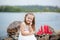 Summer day. Happy childhood carefree game on the open sand. The concept of rest. Little cute girl and scarlet sails. Girl sitting