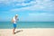 Summer Day. Happy smiling caucasian tourist asian young man holding camera for take a photo check in on the beach.