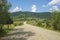 Summer day landscape with road, cloudy sky and Carpathian Mountains