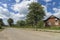 Summer day landscape with road, cloudy sky and small houses. Ukraine, Carpathian.