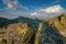 Summer day in the mountains with massive rocks, dramatic skies and majestic mountains.