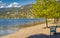 Summer day at the Okanagan lake beach in Kelowna, BC. The view on the beach with trees and benches