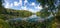 Summer day on remote calm lake in a boreal forest panorama