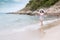 Summer Day. Smiling woman wearing fashion summer beach having fun playing splashing water in freedom on the sandy ocean beach.