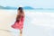 Summer Day. Smiling woman wearing fashion summer walking on the sandy ocean beach. Happy woman enjoy and relax vacation.