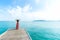 Summer Day. Smiling women relax and wearing red dress fashion standing on the wooden bridge over the sea, blue sky background