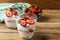 Summer dessert with whipped cream and strawberry on wooden background