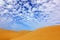 Summer dry landscape in Africa. Black pebble stones. Sandy waves in the wild nature. Dunas Maspalomas, Gran Canaria, Spain.