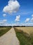 Summer empty country gravel road and clouds