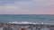 Summer evening at sea coast. Small waves surf on gray pebbles.