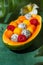 Summer exotic fruit salad in half of papaya. Healthy sweet dessert with mango, papaya, pitaya, passion fruit and raspberry