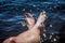 Summer feet against glimmering water.