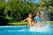 Summer fitness, kids in swimming pool have fun, smiling girls splash in water