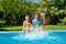 Summer fitness, kids in swimming pool have fun, smiling girls splash in water