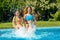 Summer fitness, kids in swimming pool have fun, smiling girls splash in water