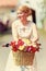 Summer flower bouquet in bicycle basket, elegant lady on background
