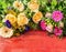 Summer flowers : roses, daisies , lilies, gerbera and anemones on red wooden background