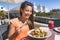 Summer food Asian woman eating vegetarian goat cheese salad at luxury travel resort after fitness exercise. Fit young girl on