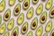 Summer food pattern. Avocado halves on pink background. Top view. Flat lay