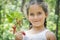 Summer in the forest on a bright sunny afternoon, a little girl, is holding strawberries in her hands.