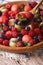 Summer fruit salad in wooden bowl closeup. vertical