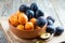 Summer fruits - plums and apricots in a bowl on wooden background