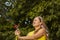 Summer garden, watering - beautiful girl watering roses with garden hose in the garden