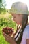 in summer garden young sweet girl in hat is holding vase with ripe, juicy cherry in her hands. Delicious and healthy food.