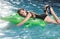 Summer girl. Beautiful exotic woman with inflatable crocodile tanning in pool. Woman in swimming pool.