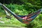 Summer girl in hammock playing with a cell phone