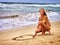 Summer girl sea. Girl in swimsuit write on sand heart shape .