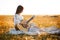 Summer is a great dream time. Beautiful girl playing the guitar in a wheat field