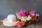 Summer hat, beautiful astilbe and hydrangea flowers, glasses of rose champagne and fresh raspberry. Selective focus.