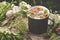 Summer healthy herbal tea in old enameled mug and bunches of healing herbs on wooden board. Herbal medicine.