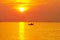 Summer holiday with big yellow sun and fishing boat silhouette at sunset